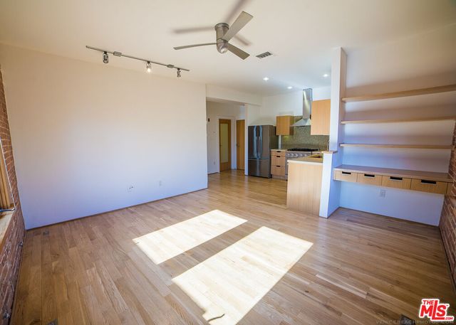 a kitchen with a wooden floor and electronic appliances