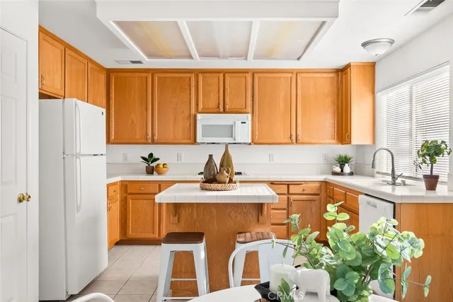 a kitchen with stainless steel appliances granite countertop a sink a stove a table and chairs