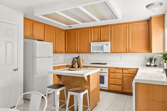 a kitchen with stainless steel appliances sink refrigerator table and chairs