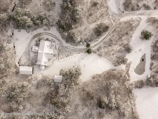 a view of a house with snow on the side of the road