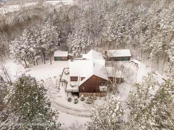 a front view of a house with snow on the road