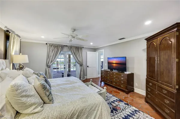 a spacious bedroom with a bed and a flat screen tv