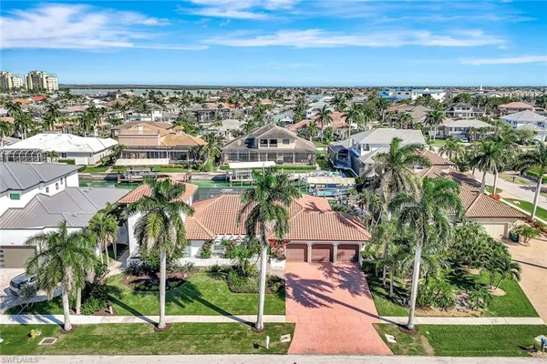 an aerial view of residential houses with outdoor space and ocean view