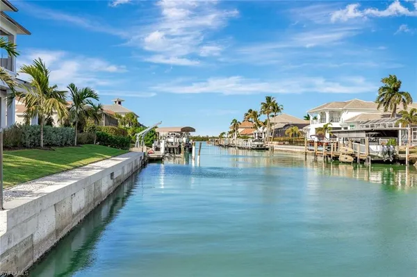 an aerial view of a city with lots of residential buildings ocean and mountain view in back