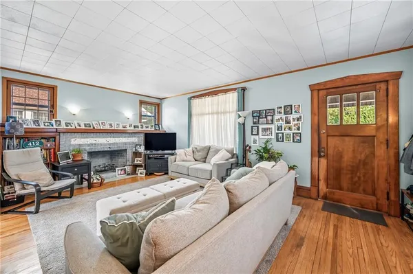 a living room with furniture a large window and wooden floor