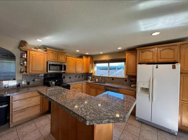 a kitchen with stainless steel appliances granite countertop a sink stove and refrigerator