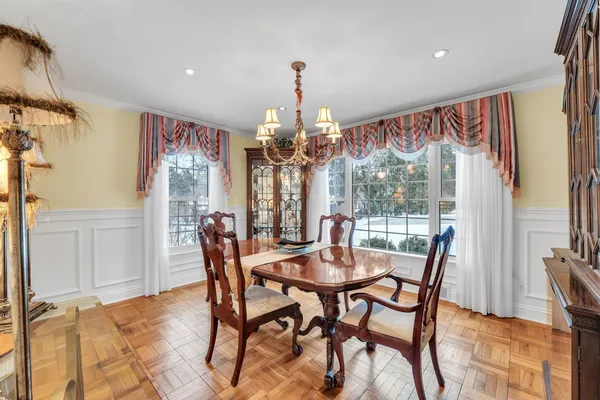 a dining room with furniture a chandelier and wooden floor