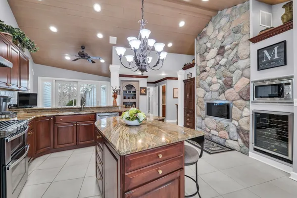 a kitchen with kitchen island granite countertop a stove oven and a sink