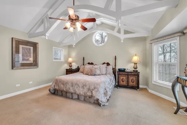 a spacious bedroom with a bed a chandelier and a chandelier