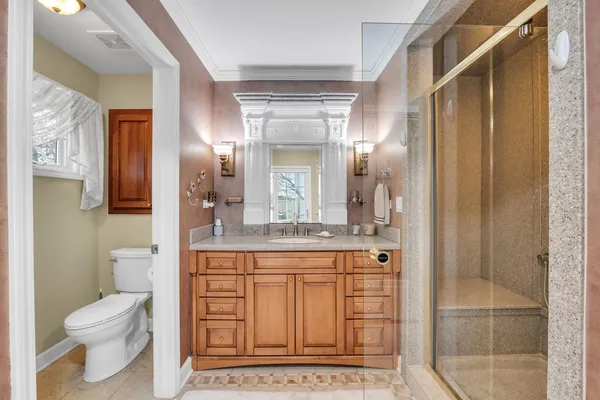 a bathroom with a granite countertop sink a toilet and a mirror