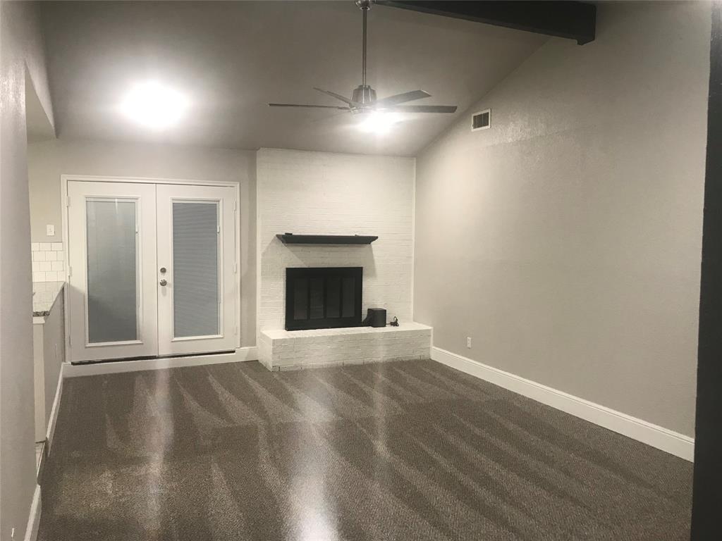 an empty room with wooden floor a ceiling fan and windows
