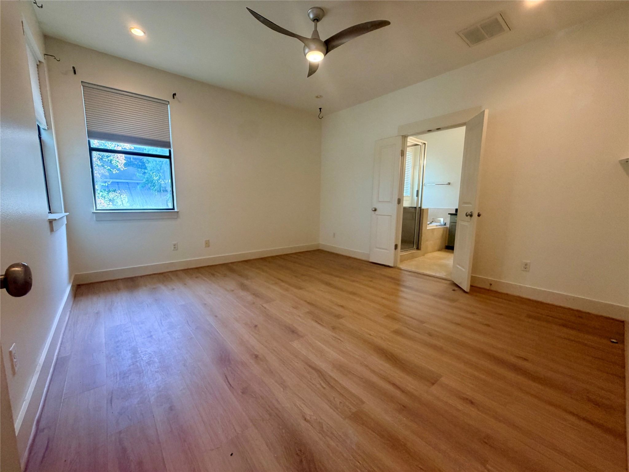 4120 Valley View Road, Unit A Austin, TX 78704 - Photo 5 of 16 A well-lit primary bedroom featuring durable hardwood-style flooring and direct access to a private bath