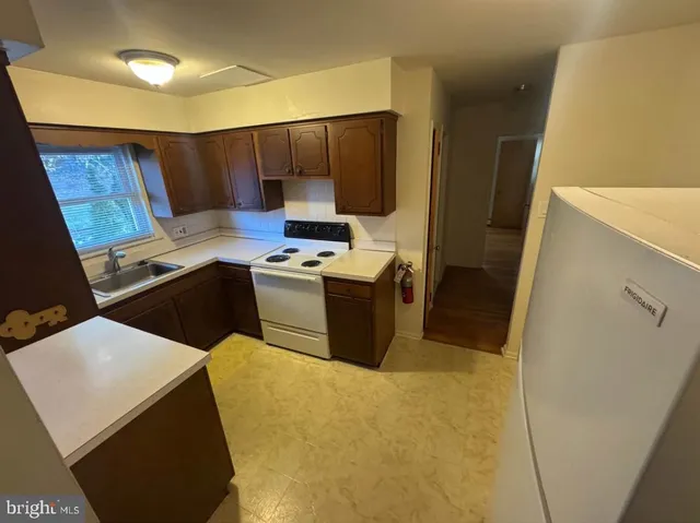a kitchen with a sink a stove and a refrigerator