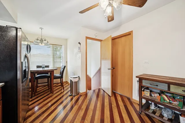 a view of a hallway with wooden floor and dining room