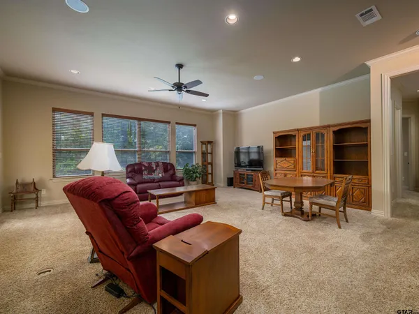 a living room with furniture a flat screen tv and a large window