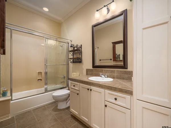 a bathroom with a granite countertop sink toilet and shower