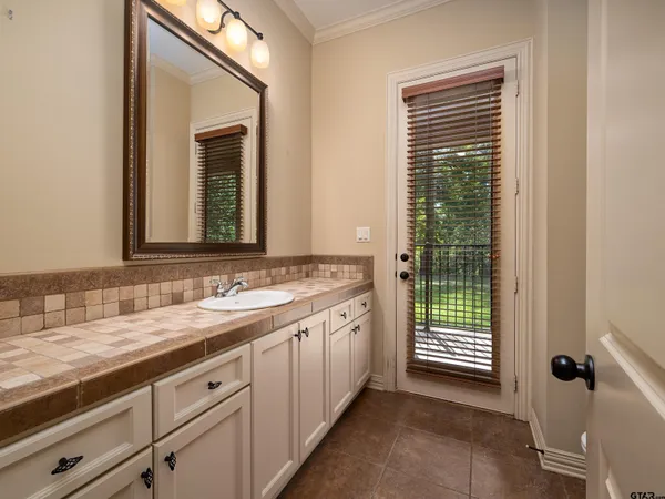 a bathroom with a granite countertop sink and a mirror