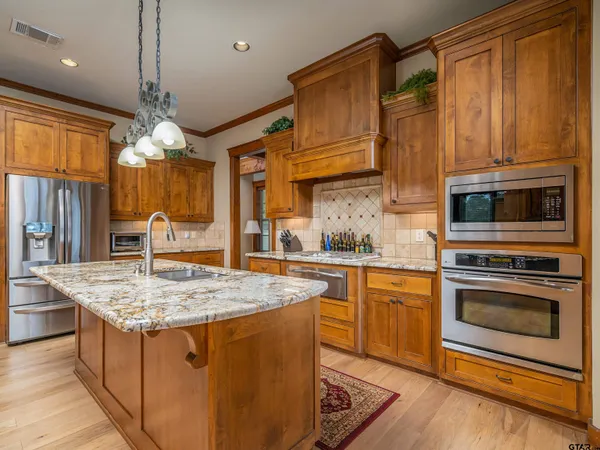 a kitchen with stainless steel appliances granite countertop a sink stove and refrigerator