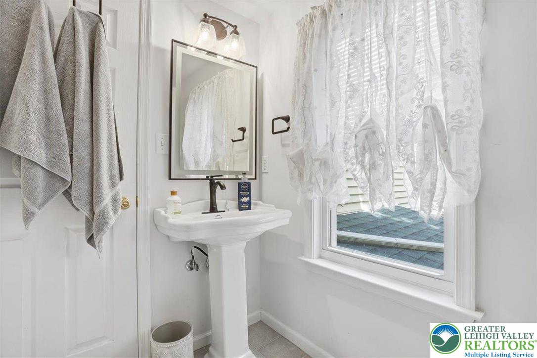 4880 Little Gap Road Kunkletown, PA 18058 - Photo 38 of 100 This bathroom features a sleek pedestal sink and ample natural light through a large window.