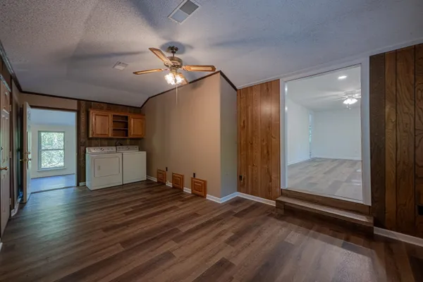 a view of an empty room with window and wooden floor