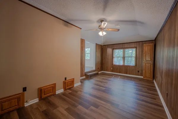 a view of an empty room with a window and wooden floor