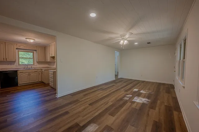 a view of a kitchen with a sink and dishwasher a refrigerator with wooden floor