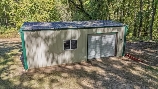 a view of a small house with wooden fence
