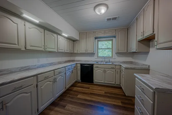 a kitchen with granite countertop cabinets stainless steel appliances a sink and window