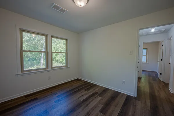 a view of a room with wooden floor and window