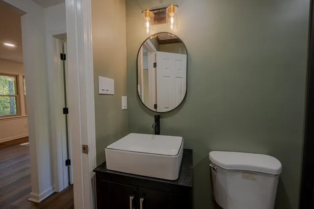 a bathroom with a toilet a sink and mirror