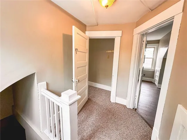 a view of a hallway with furniture and wooden floor
