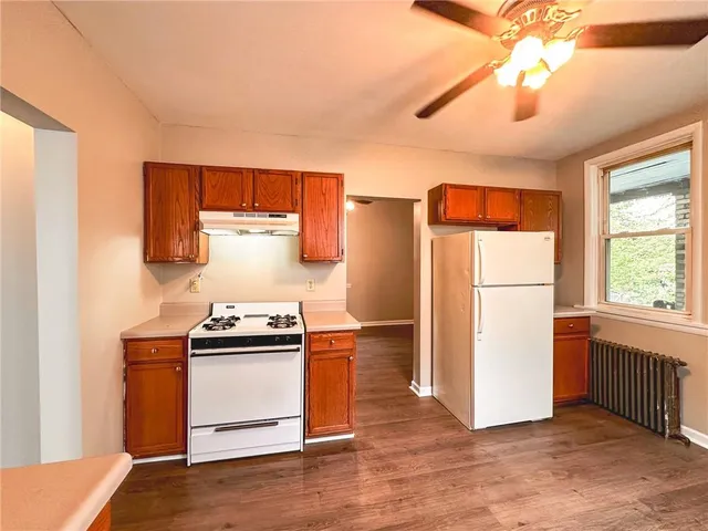 a kitchen with a stove a refrigerator and a stove top oven