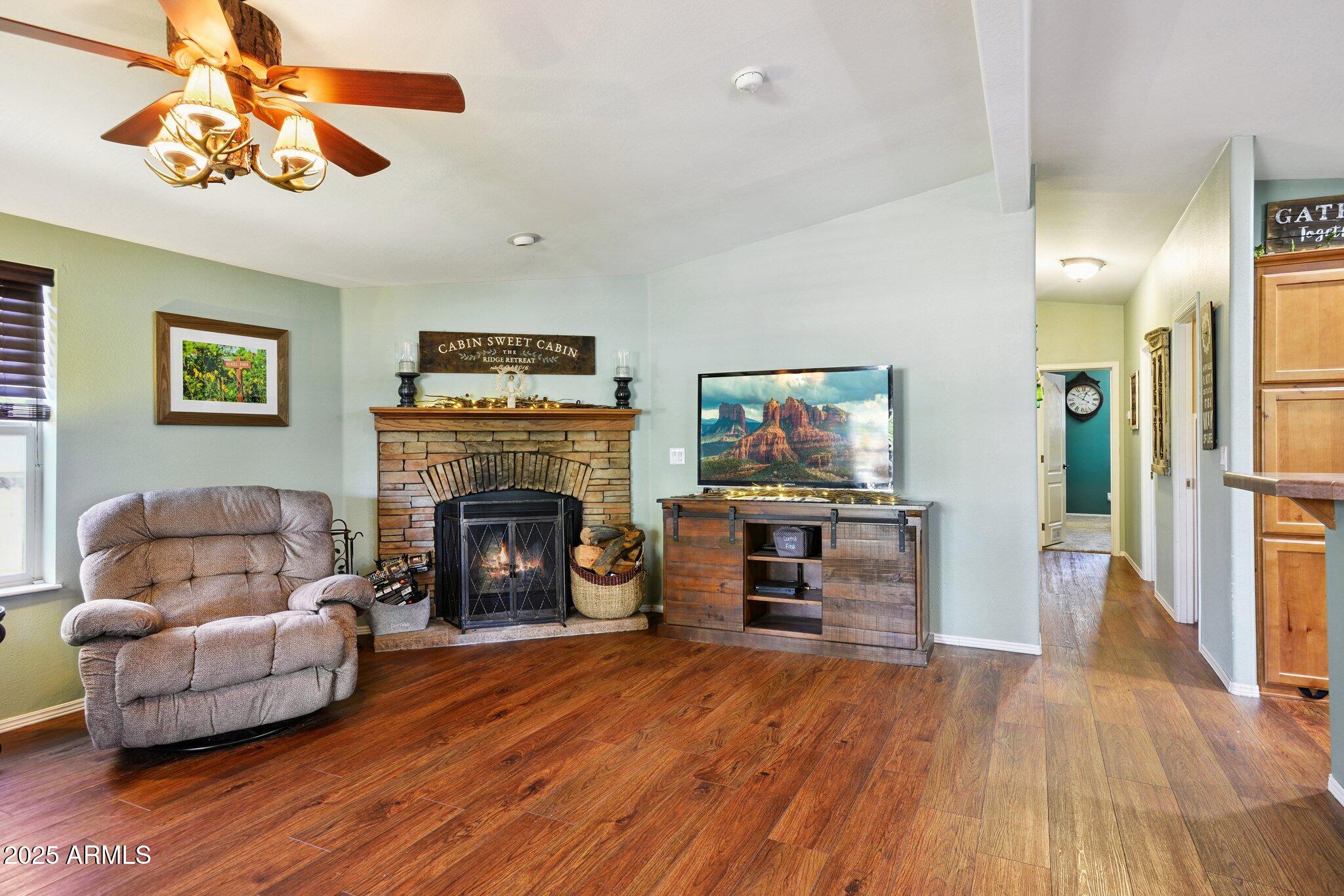 1220 Caribou Road Munds Park, AZ 86017 - Photo 10 of 42 a living room with furniture and a fireplace