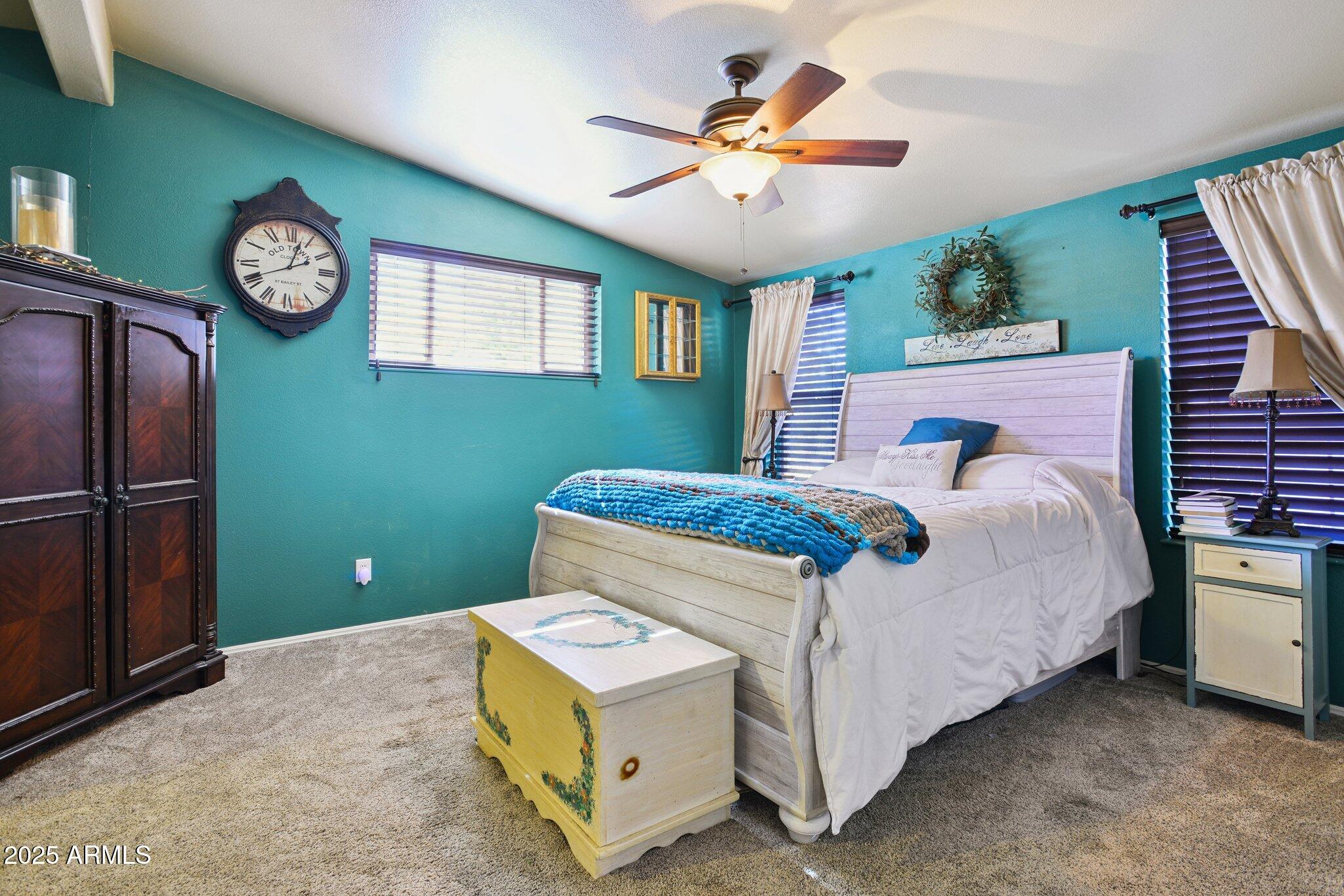 1220 Caribou Road Munds Park, AZ 86017 - Photo 17 of 42 a bedroom with a large bed and a chandelier