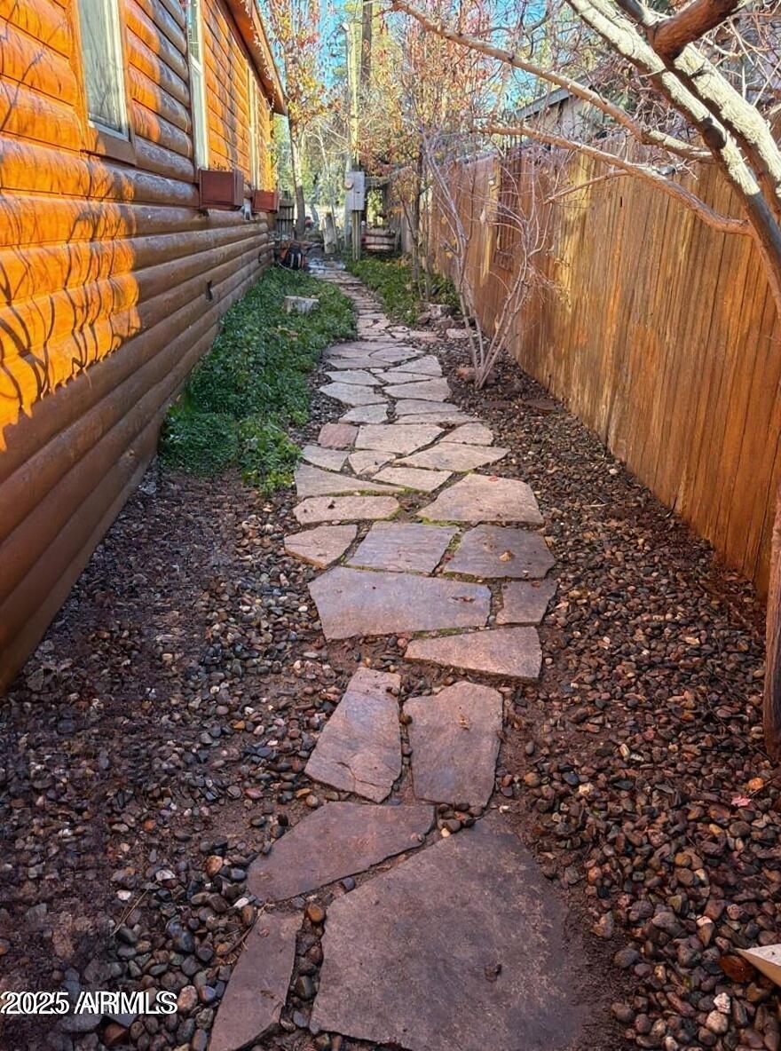 1220 Caribou Road Munds Park, AZ 86017 - Photo 7 of 42 a view of a pathway of a yard with wooden fence