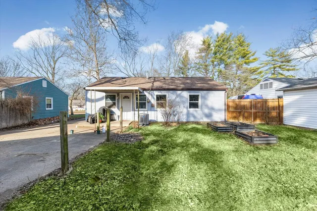 a view of a house with a backyard and a tree