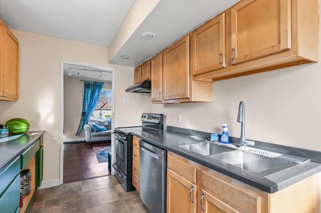 a kitchen with stainless steel appliances granite countertop a sink stove and cabinets
