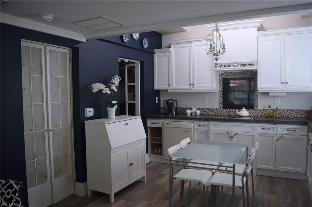 5318 Treetops Drive, Unit IG3 Naples, FL 34113 - Photo 4 of 13 a kitchen with a white cabinets and chairs