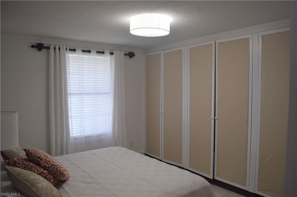 5318 Treetops Drive, Unit IG3 Naples, FL 34113 - Photo 6 of 13 a bedroom with a bed and a window
