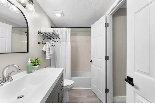a bathroom with a sink toilet and shower