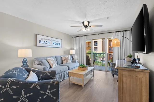 a living room with furniture ceiling fan and a flat screen tv