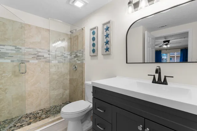 a bathroom with a sink a toilet and shower