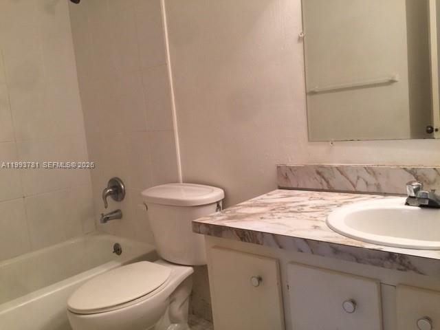 7913 Southwest 104th Street, Unit G207 Miami, FL 33156 - Photo 11 of 11 a bathroom with a granite countertop sink toilet and shower