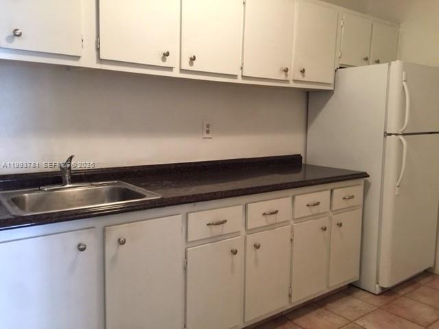 7913 Southwest 104th Street, Unit G207 Miami, FL 33156 - Photo 8 of 11 a kitchen with granite countertop white cabinets and a sink