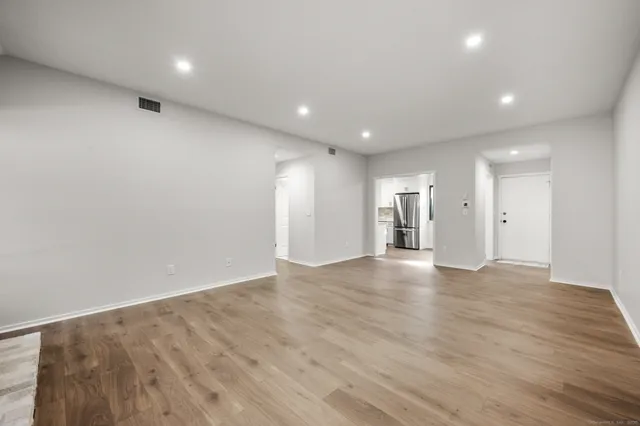 a view of an empty room with wooden floor