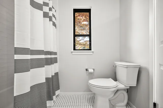 a bathroom with a toilet a sink and a window