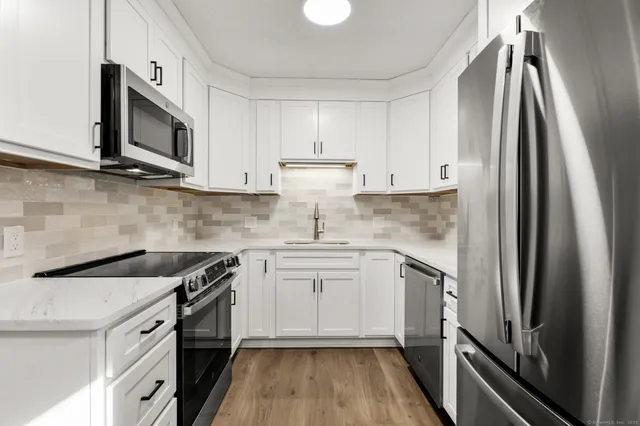 a kitchen with stainless steel appliances a sink stove and refrigerator