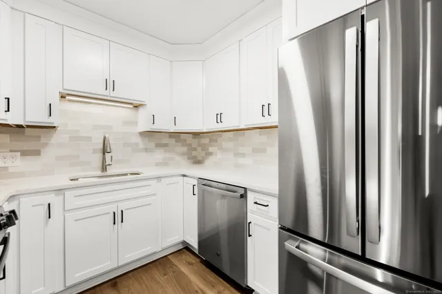 a kitchen with white cabinets and white appliances