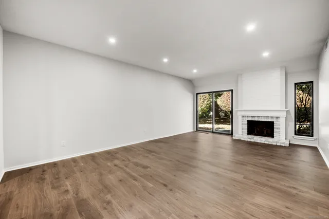 an empty room with wooden floor and fireplace