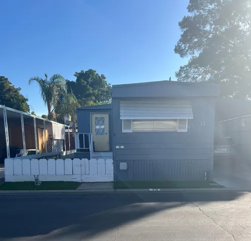 a view of backyard with wooden fence and large trees
